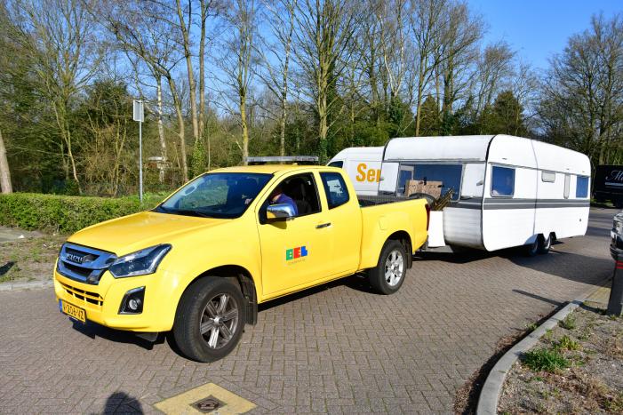 Handhaving sleept caravan met protesttekst weg van parkeerterrein gemeentewerf