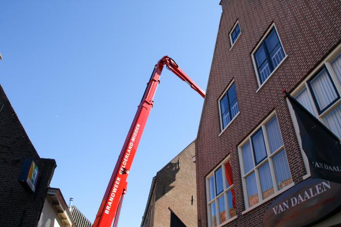 Brandweer verwijdert losliggende dakpannen winkelpand