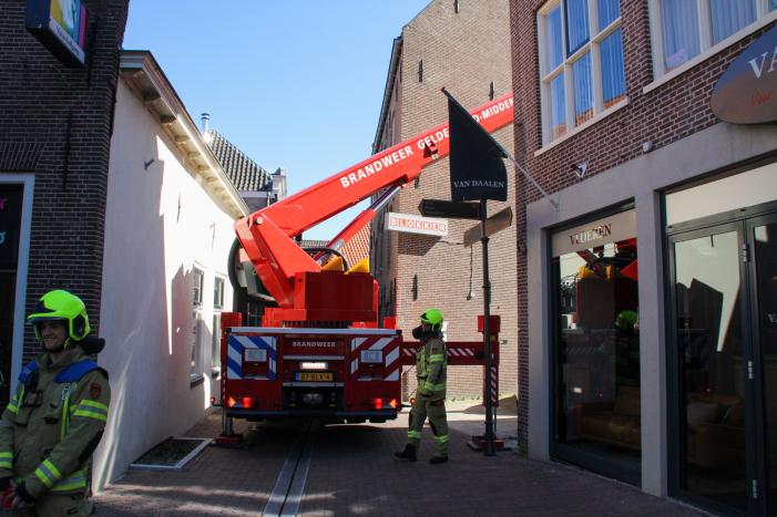 Brandweer verwijdert losliggende dakpannen winkelpand