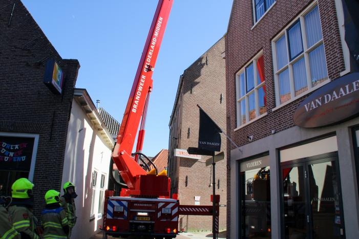 Brandweer verwijdert losliggende dakpannen winkelpand