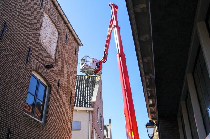 Brandweer verwijdert losliggende dakpannen winkelpand