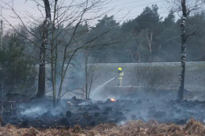 Groot stuk bosschage langs spoor in brand
