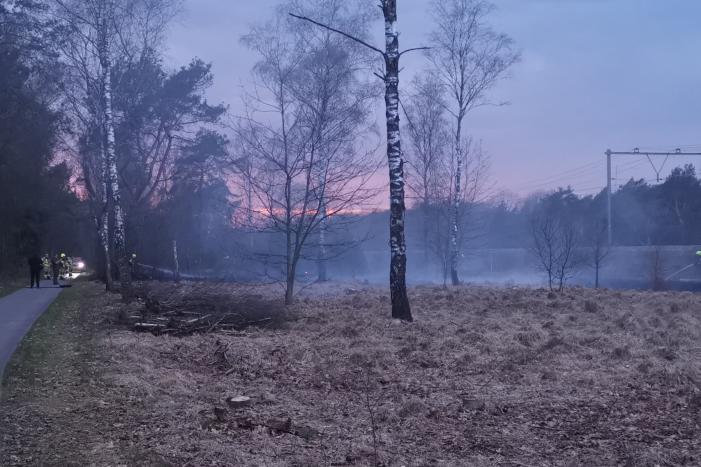 Groot stuk bosschage langs spoor in brand