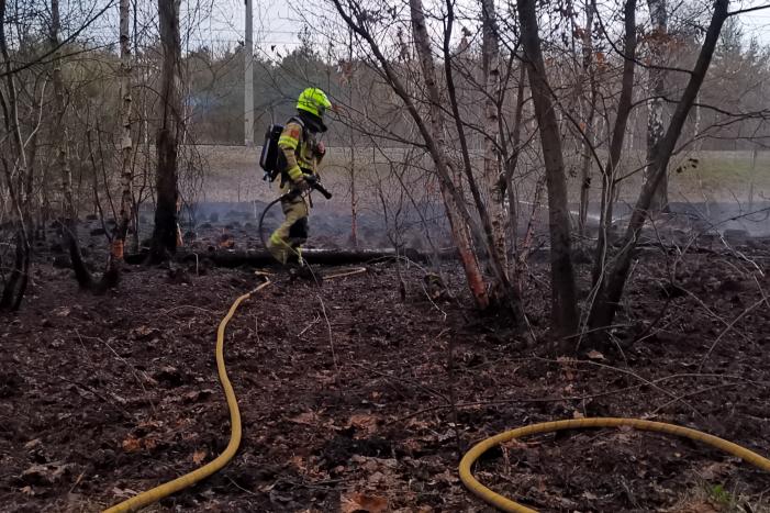 Groot stuk bosschage langs spoor in brand