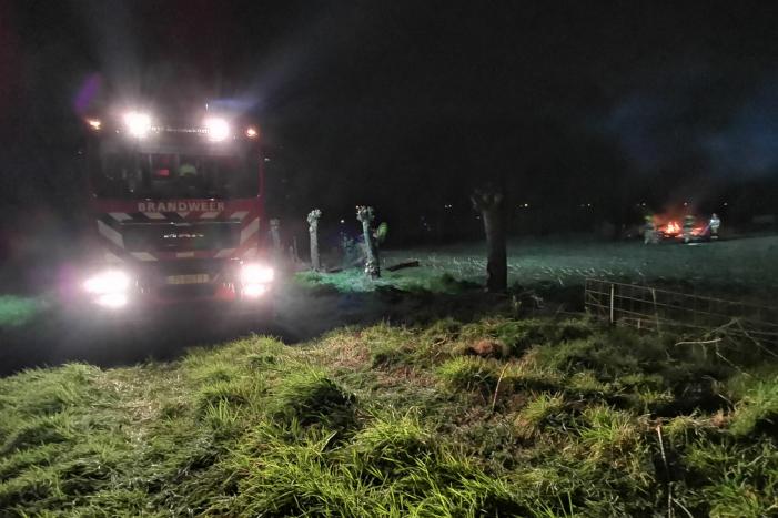 Berg met takken in weiland vatte vlam