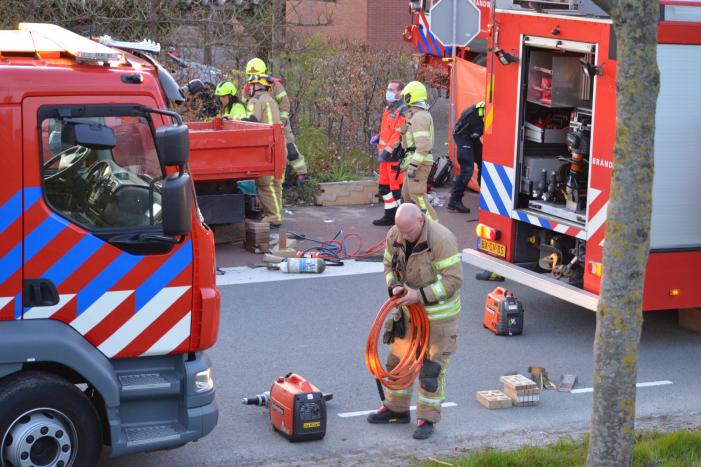 Man bekneld onder as van bedrijfswagen
