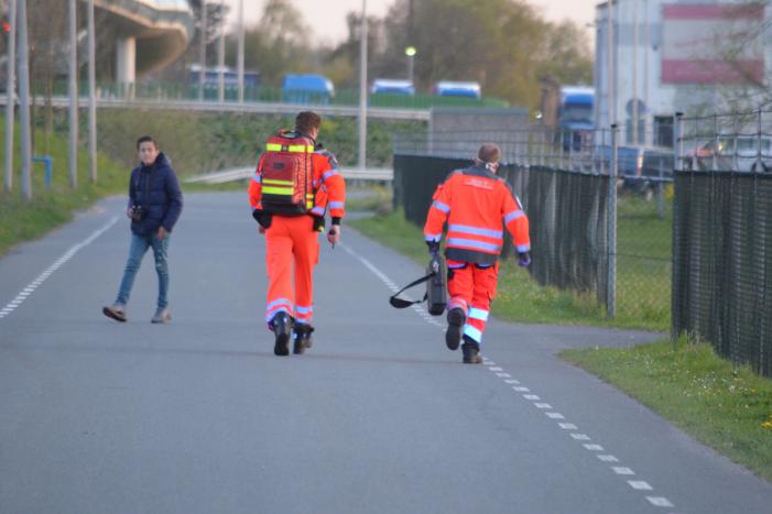 Man bekneld onder as van bedrijfswagen