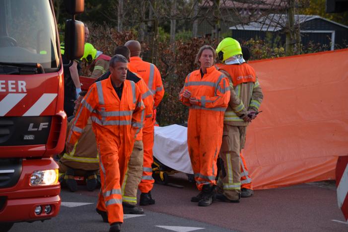 Man bekneld onder as van bedrijfswagen