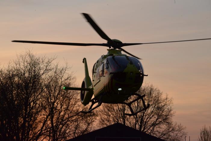 Man bekneld onder as van bedrijfswagen