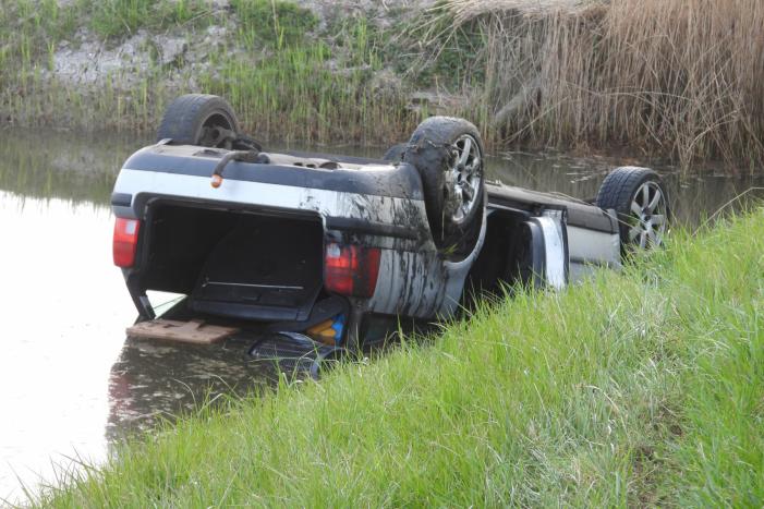 Auto op zijn kop in de sloot
