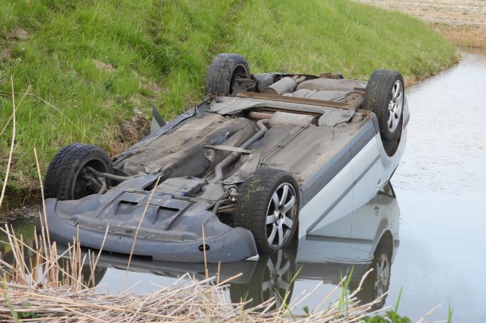 Auto op zijn kop in de sloot