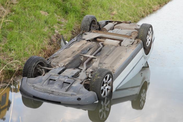 Auto op zijn kop in de sloot