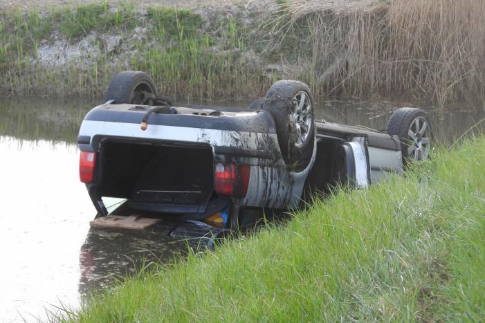 Auto op zijn kop in de sloot