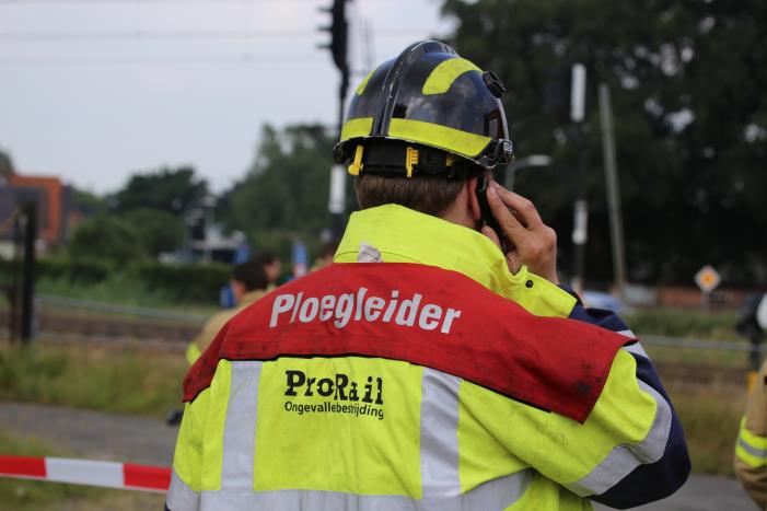 Treinen rijden stapvoets door spelende kinderen met bal op spoor