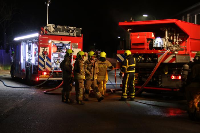Meerdere voertuigen in brand tegen gevel bedrijfspand