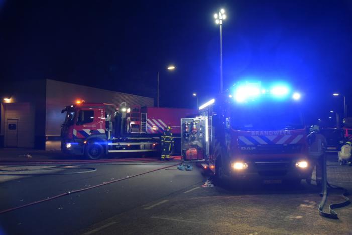 Meerdere voertuigen in brand tegen gevel bedrijfspand