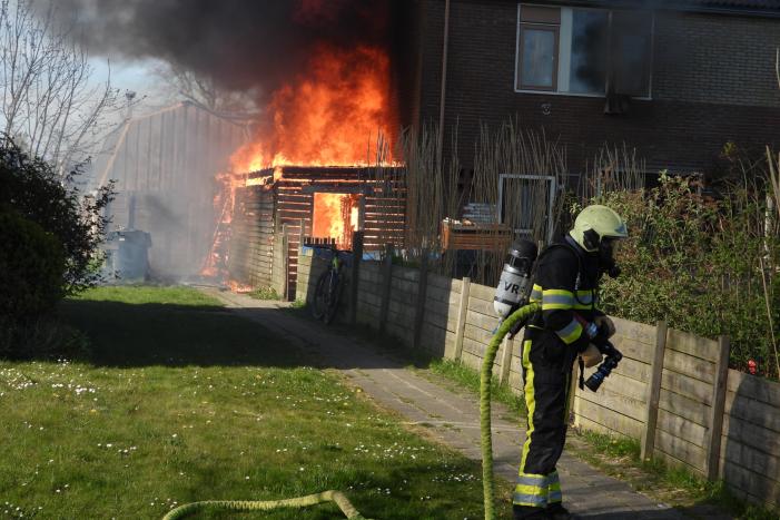Uitslaande brand in schuur tegen woning aan