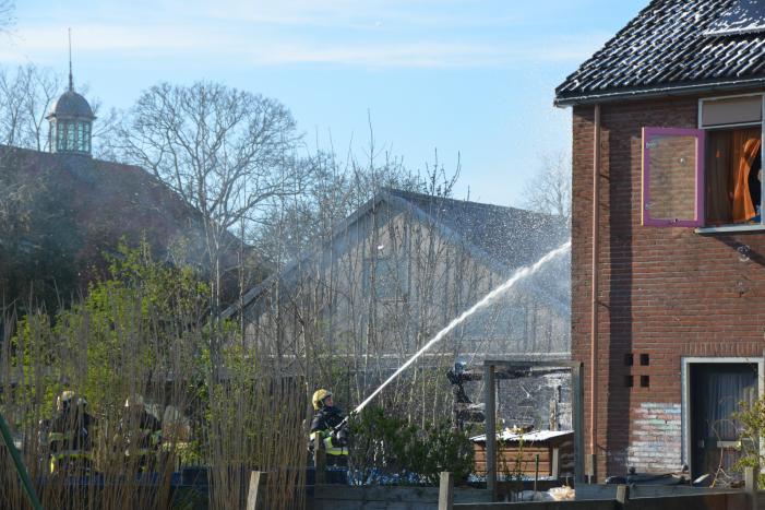 Uitslaande brand in schuur tegen woning aan