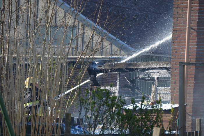 Uitslaande brand in schuur tegen woning aan