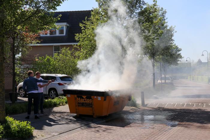 Bewoners blussen brand in bouwcontainer met puin