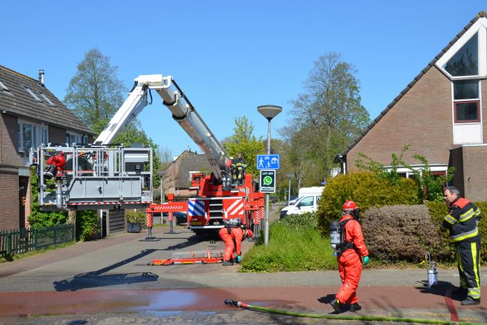 Brandweer in beschermende pakken halen persoon uit woning