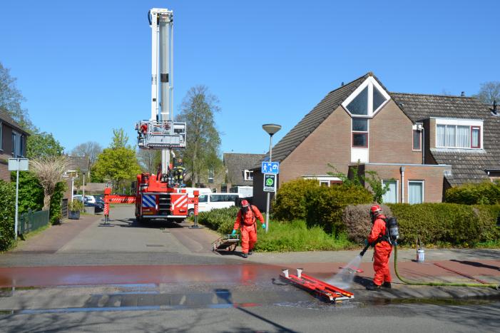 Brandweer in beschermende pakken halen persoon uit woning
