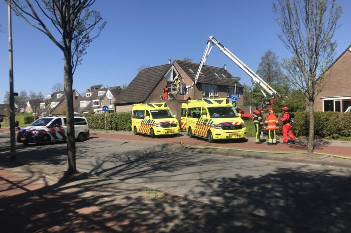 Brandweer in beschermende pakken halen persoon uit woning