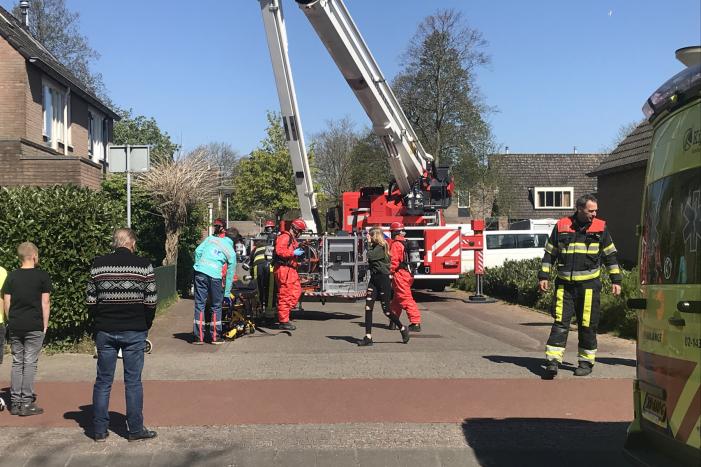 Brandweer in beschermende pakken halen persoon uit woning
