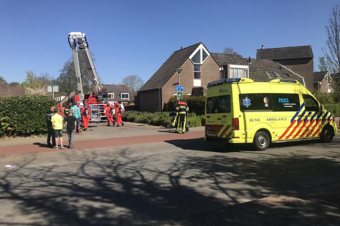 Brandweer in beschermende pakken halen persoon uit woning