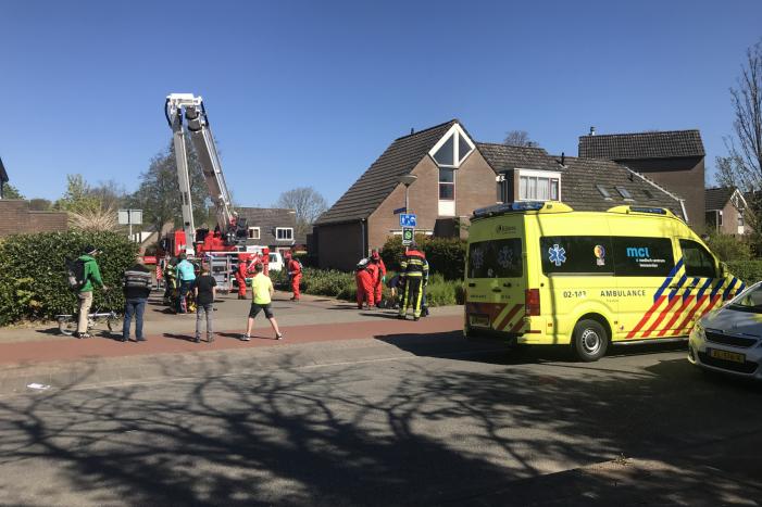 Brandweer in beschermende pakken halen persoon uit woning