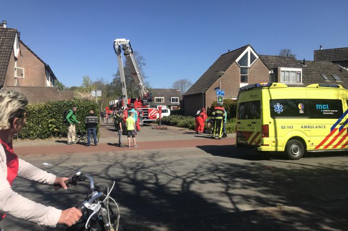 Brandweer in beschermende pakken halen persoon uit woning