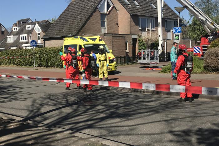 Brandweer in beschermende pakken halen persoon uit woning