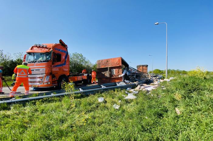 Vrachtwagen met afval gekanteld op afrit