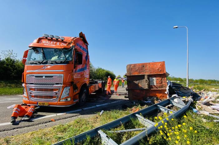 Vrachtwagen met afval gekanteld op afrit