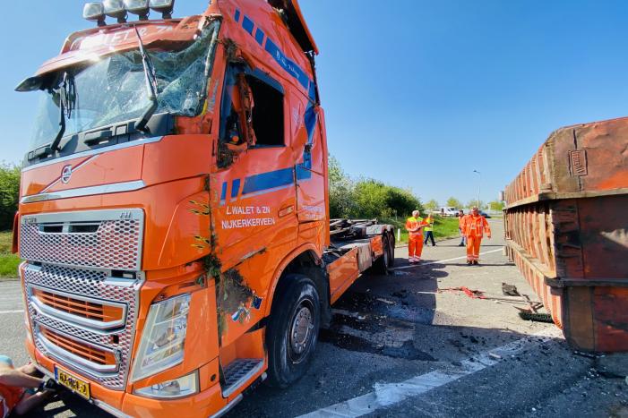 Vrachtwagen met afval gekanteld op afrit