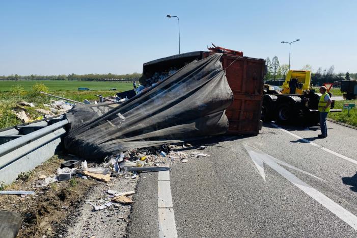 Vrachtwagen met afval gekanteld op afrit