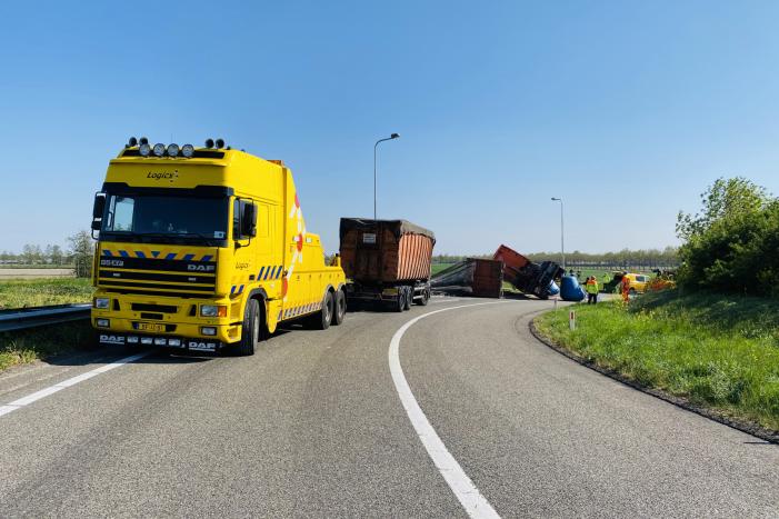 Vrachtwagen met afval gekanteld op afrit