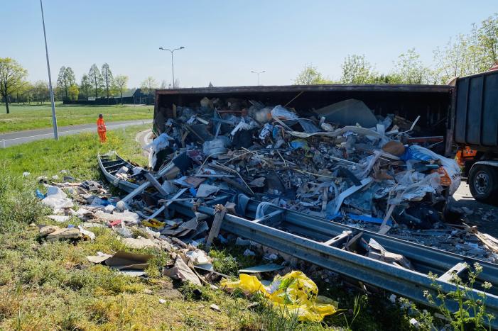 Vrachtwagen met afval gekanteld op afrit