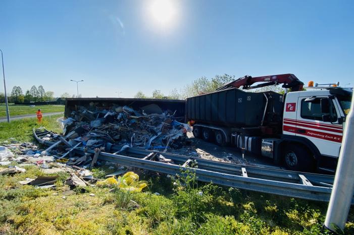 Vrachtwagen met afval gekanteld op afrit
