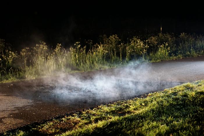 Brandweer blust brandend asfalt