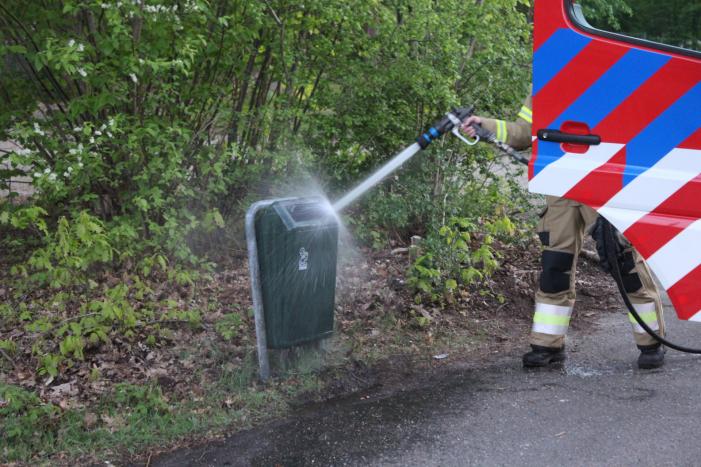 Omstanders doven vuur in prullenbak op parkeerterrein