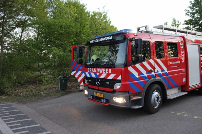Omstanders doven vuur in prullenbak op parkeerterrein