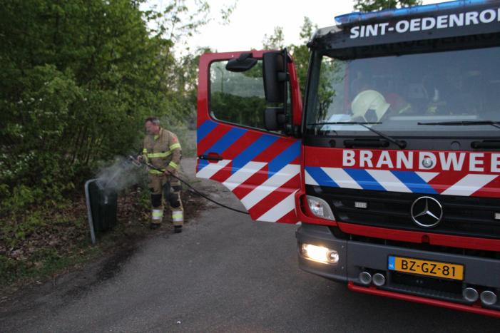 Omstanders doven vuur in prullenbak op parkeerterrein