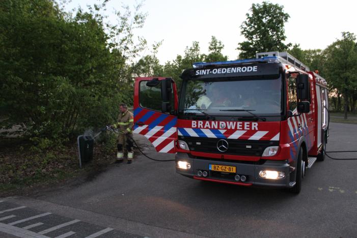 Omstanders doven vuur in prullenbak op parkeerterrein