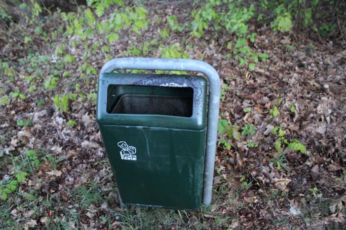 Omstanders doven vuur in prullenbak op parkeerterrein