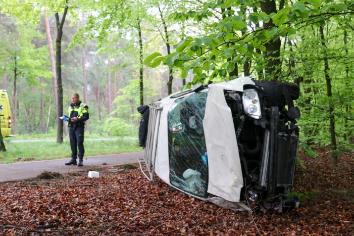 Bestelbus belandt op zijn kant in bosschage