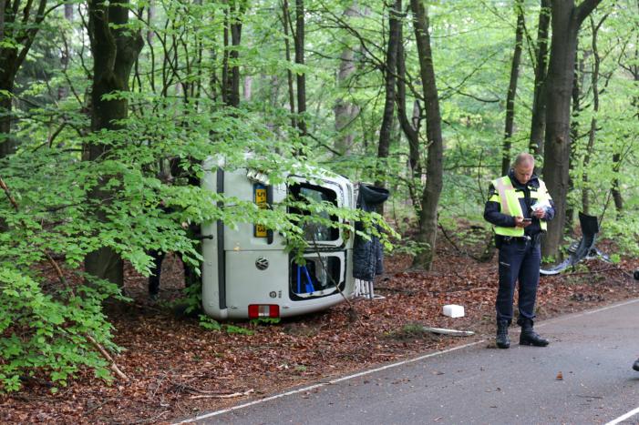 Bestelbus belandt op zijn kant in bosschage