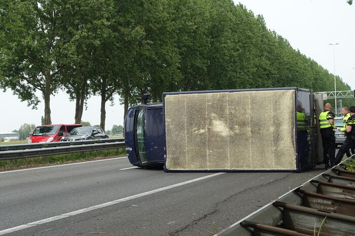 Bestelbus belandt op zijn kant, vrachtwagen ramt vangrail