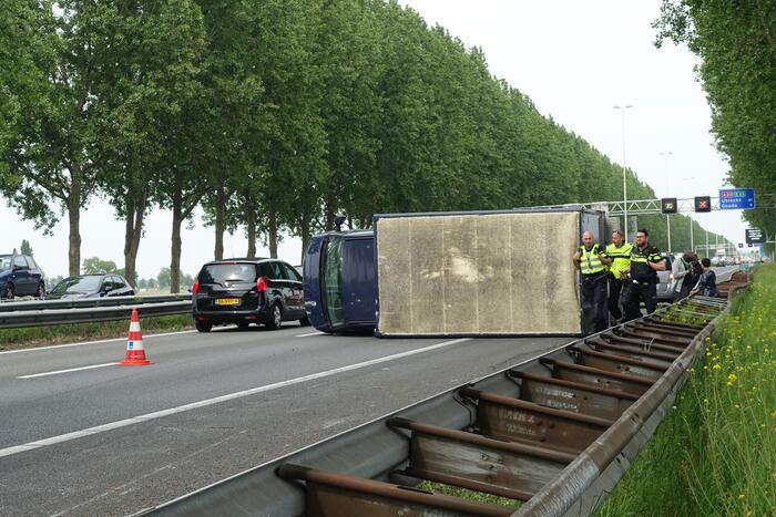Bestelbus belandt op zijn kant, vrachtwagen ramt vangrail