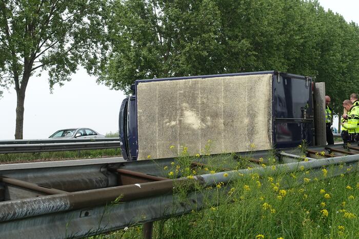 Bestelbus belandt op zijn kant, vrachtwagen ramt vangrail